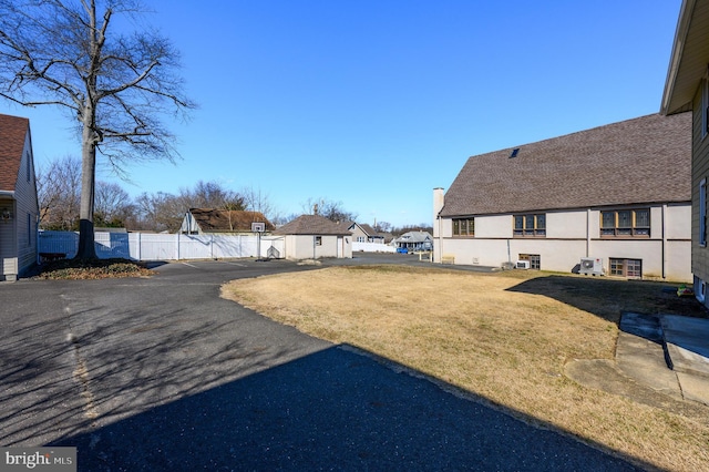 view of yard with an outbuilding, fence, and a residential view