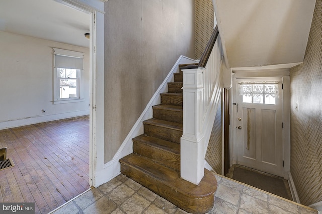 entrance foyer with hardwood / wood-style flooring, stairs, baseboards, and wallpapered walls