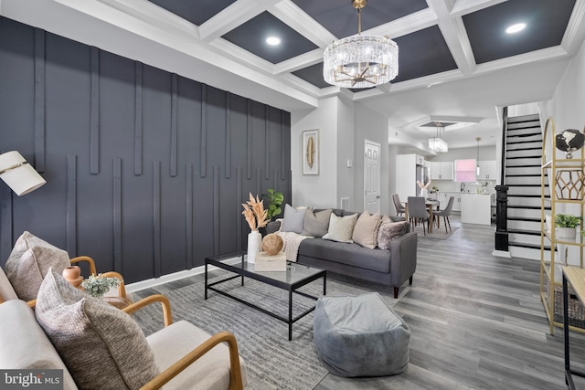 living room with a chandelier, wood finished floors, beamed ceiling, and stairs