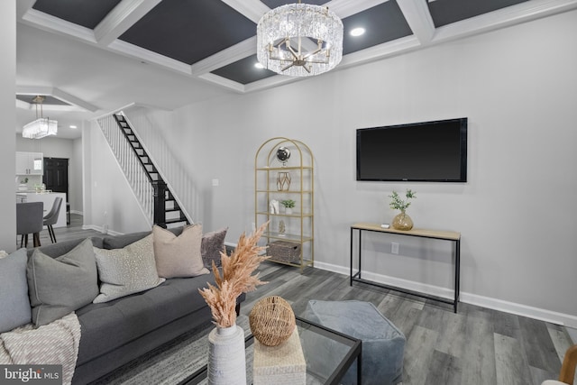 living area with stairway, a notable chandelier, and wood finished floors