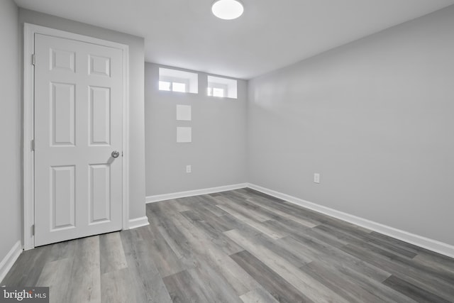 below grade area featuring wood finished floors and baseboards