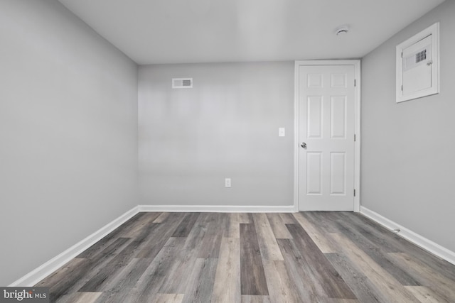 below grade area featuring baseboards, visible vents, and wood finished floors