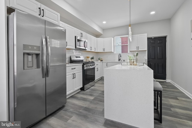 kitchen with appliances with stainless steel finishes, white cabinets, and dark wood-style flooring