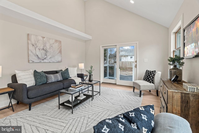 living room featuring recessed lighting, high vaulted ceiling, and light wood-style flooring