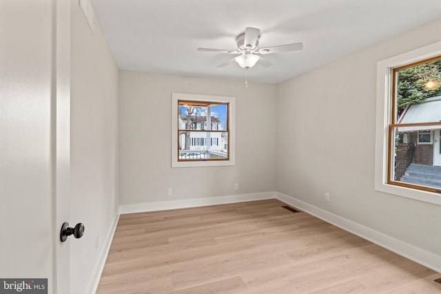 unfurnished room with ceiling fan, baseboards, and light wood-style flooring