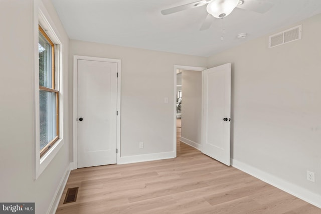 unfurnished bedroom with ceiling fan, visible vents, baseboards, and light wood-style flooring