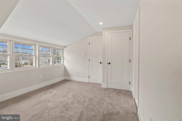 unfurnished room featuring recessed lighting, baseboards, lofted ceiling, and carpet flooring