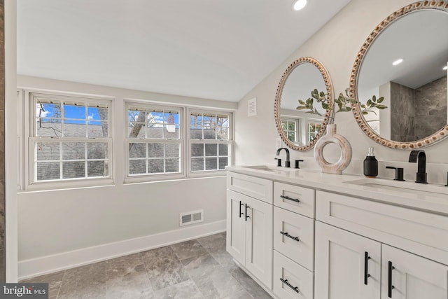 full bathroom featuring vaulted ceiling, visible vents, and a sink