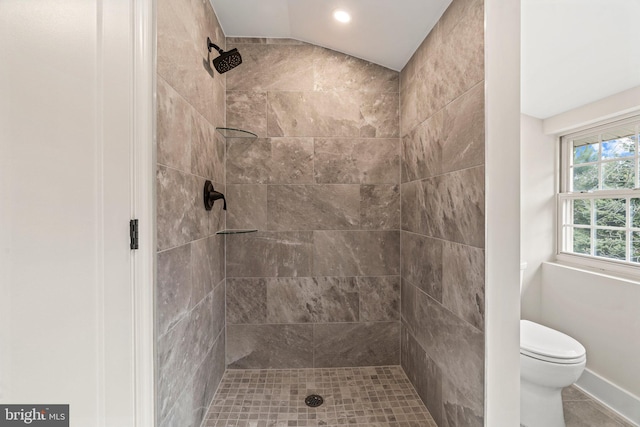 full bath with lofted ceiling, toilet, and tiled shower