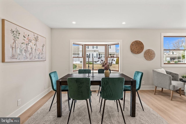 dining space with plenty of natural light, recessed lighting, baseboards, and light wood finished floors