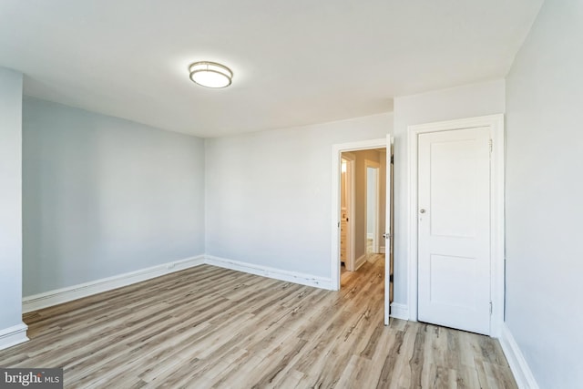 empty room featuring light wood-style flooring and baseboards