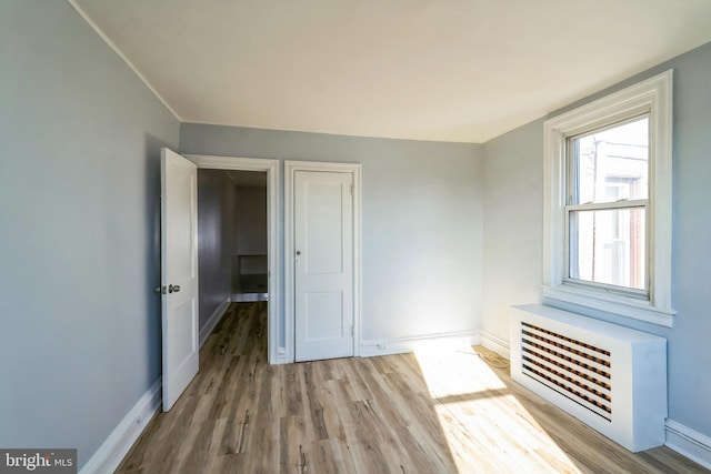 unfurnished bedroom with a closet, wood finished floors, and baseboards