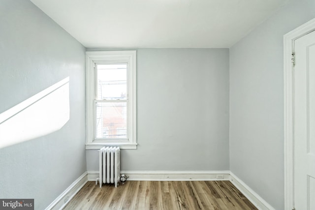 additional living space with radiator heating unit, wood finished floors, and baseboards