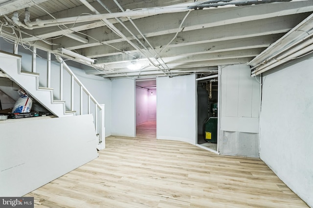 unfinished basement with stairs and wood finished floors