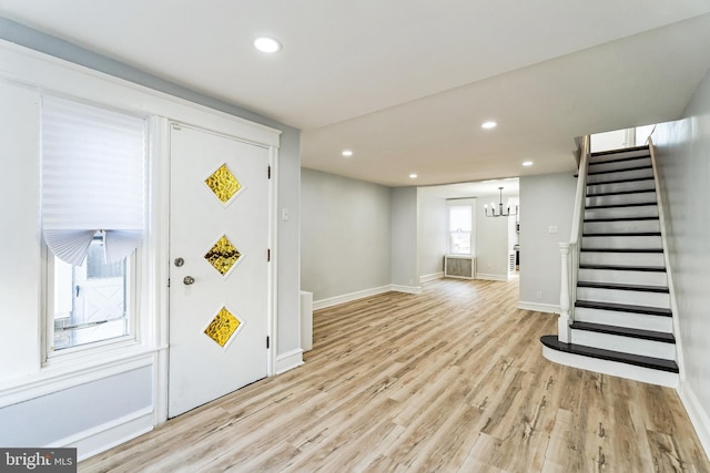 foyer with baseboards, light wood-style flooring, stairs, a notable chandelier, and recessed lighting