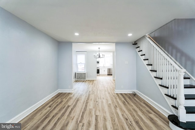 unfurnished living room with stairs, recessed lighting, wood finished floors, and baseboards