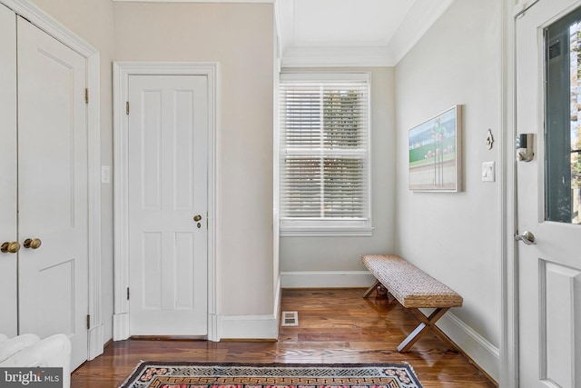 interior space with ornamental molding, wood finished floors, and baseboards