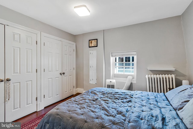 bedroom with dark wood-style floors and radiator