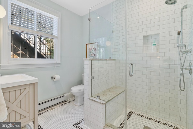 bathroom with a stall shower, toilet, a baseboard radiator, tile patterned flooring, and vanity