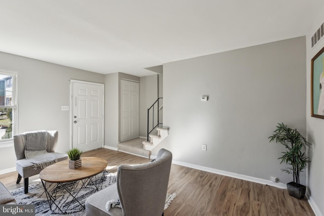 living room with wood finished floors, baseboards, and stairs