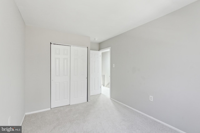 unfurnished bedroom with carpet, baseboards, and a closet