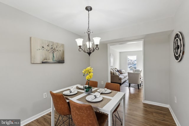 dining room with a chandelier, wood finished floors, and baseboards