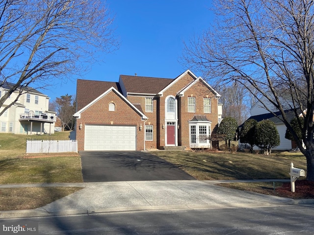 view of front of property featuring aphalt driveway, a garage, brick siding, fence, and a front yard