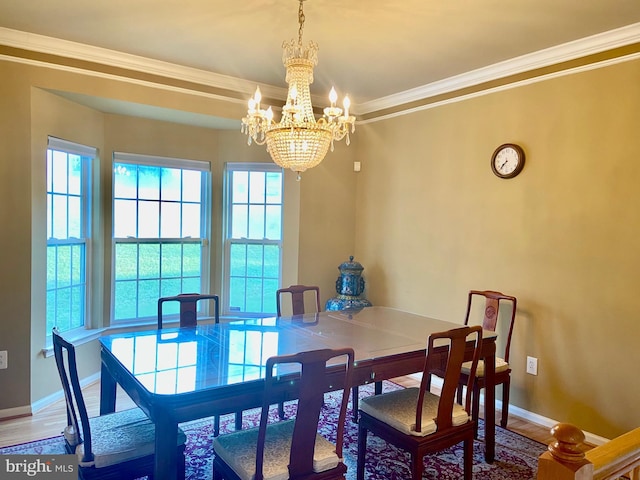 dining space featuring baseboards, ornamental molding, and wood finished floors