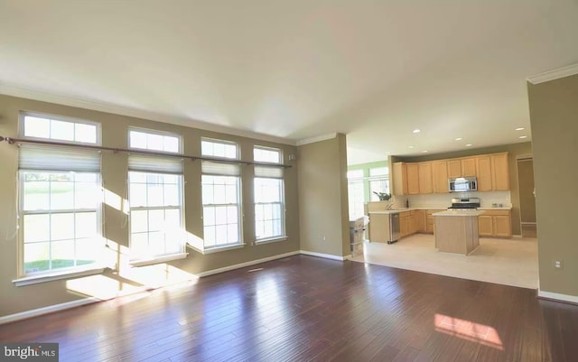 unfurnished living room featuring light wood-style flooring, baseboards, and crown molding