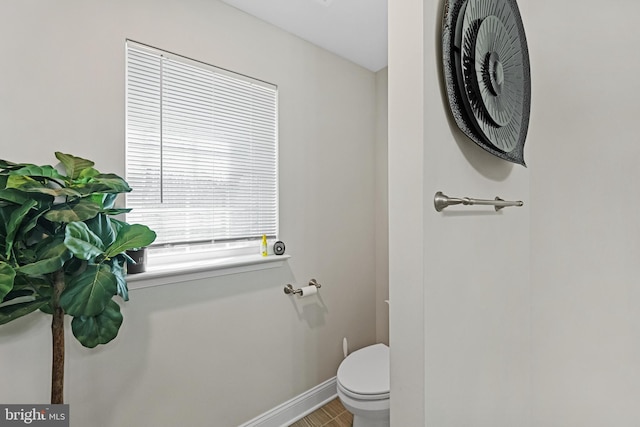 bathroom featuring baseboards and toilet