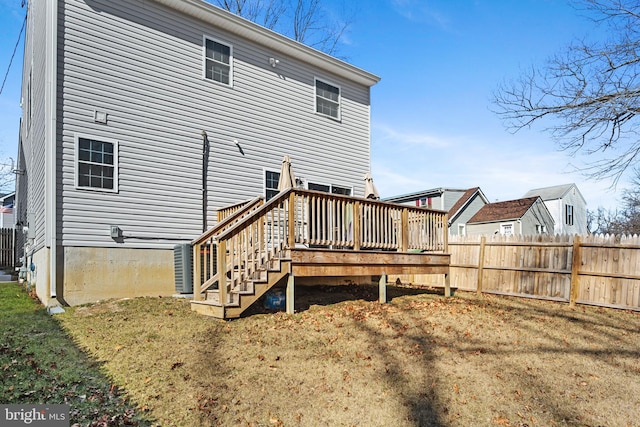 back of property featuring a lawn, fence, and a wooden deck