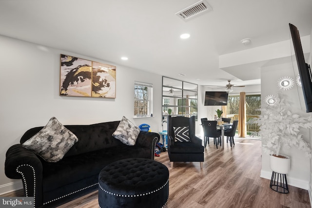 living area with baseboards, visible vents, wood finished floors, and recessed lighting