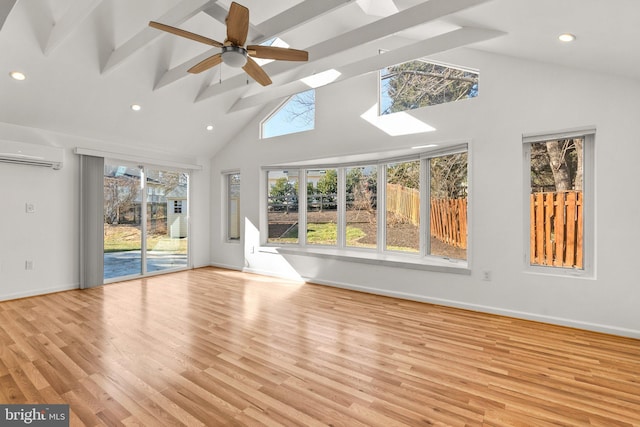 unfurnished living room featuring light wood-type flooring, beam ceiling, baseboards, and a wall mounted AC