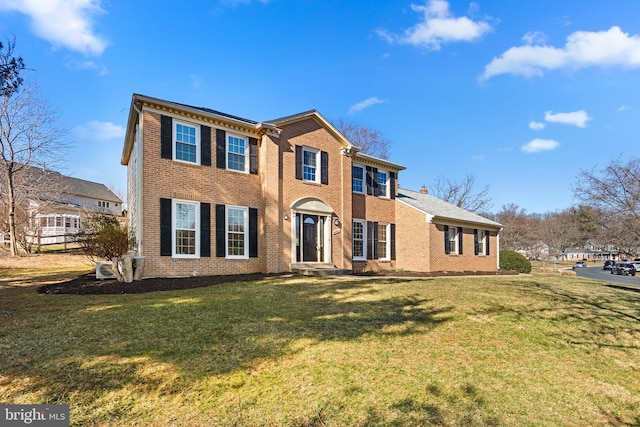 colonial house with a front yard and brick siding