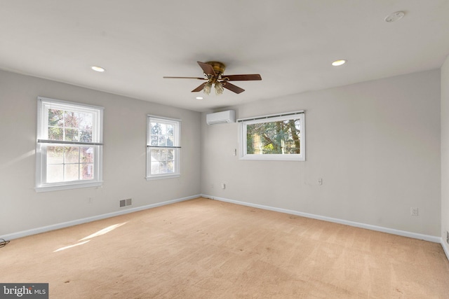 unfurnished room with light carpet, a wall mounted air conditioner, visible vents, and baseboards