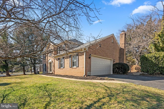 view of side of property featuring brick siding, a yard, a chimney, an attached garage, and driveway