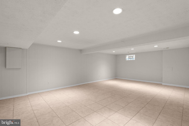 unfurnished room featuring recessed lighting, a textured ceiling, and baseboards