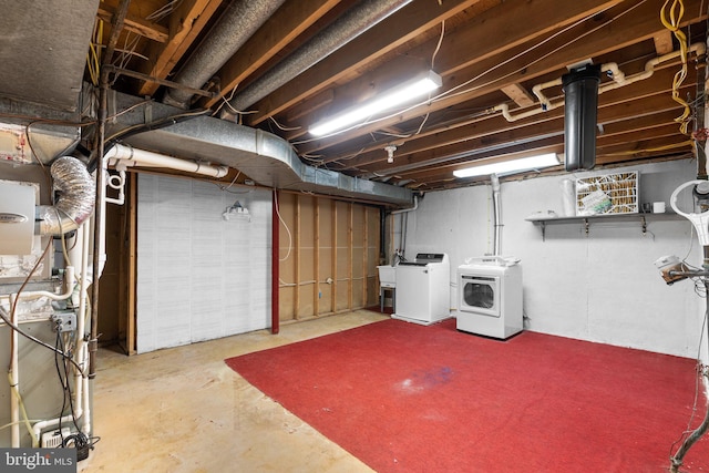 unfinished basement featuring independent washer and dryer and a sink