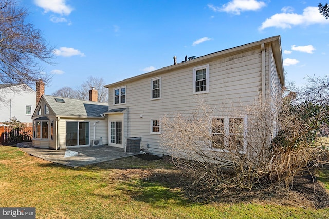 back of house featuring a chimney, a yard, central AC, and a patio area