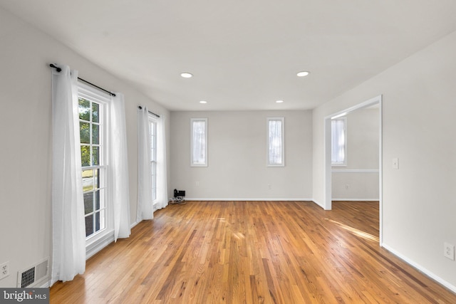 spare room featuring light wood finished floors, recessed lighting, visible vents, and baseboards