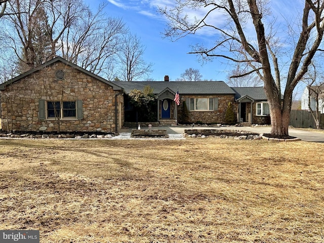 single story home featuring stone siding and a chimney