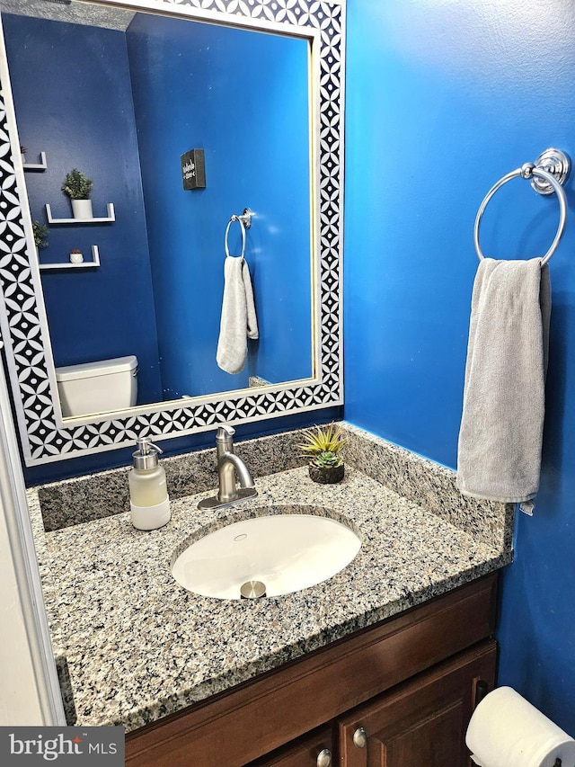 half bathroom with toilet and vanity