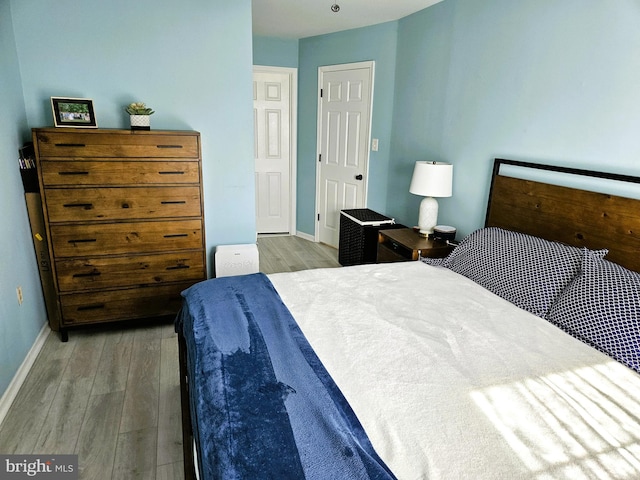 bedroom with baseboards and wood finished floors