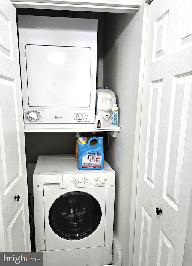 laundry room featuring laundry area and stacked washer / drying machine