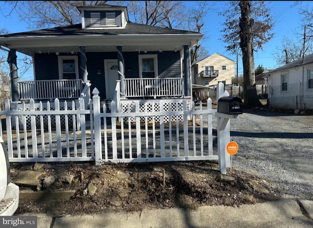 bungalow featuring a fenced front yard and a porch