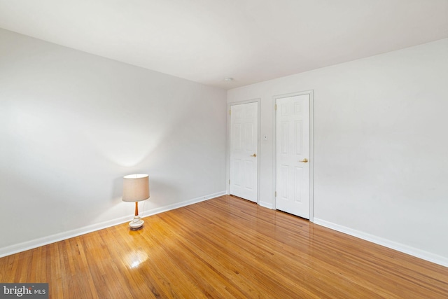 unfurnished bedroom featuring wood finished floors and baseboards