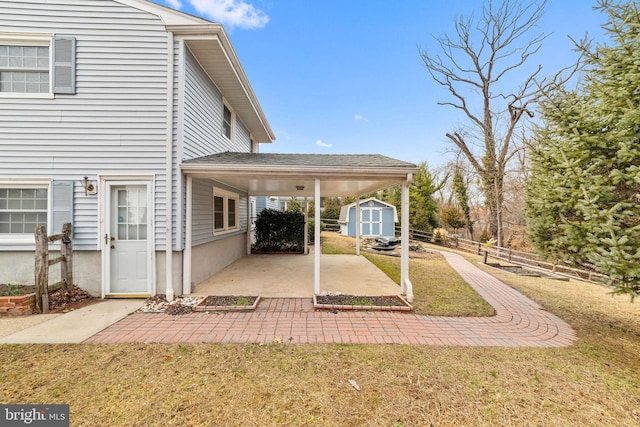 exterior space with a storage shed, a lawn, a patio, an outbuilding, and fence