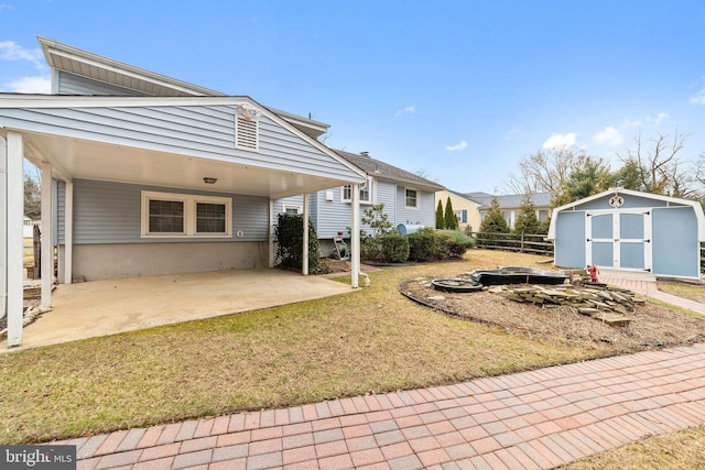 view of yard with a patio, an outbuilding, fence, a shed, and a carport