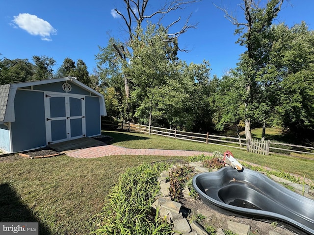 view of yard with a storage shed, fence, and an outbuilding