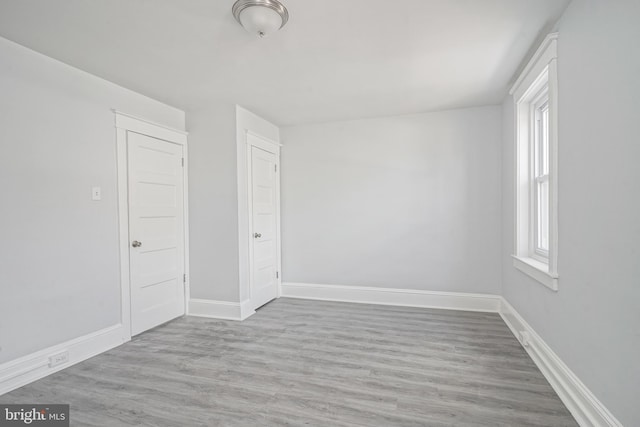 empty room with baseboards and wood finished floors